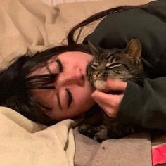 a woman laying in bed with her cat