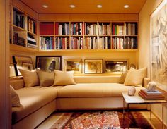 a living room filled with lots of furniture and bookshelves covered in shelves full of books