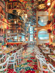 the interior of a restaurant with colorful carpeting and white chairs on either side of tables