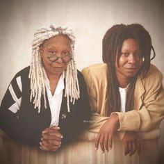 two women sitting next to each other with dreadlocks on their heads and arms