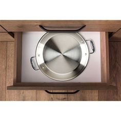 an overhead view of a metal pan in a wooden cabinet with white and black trim