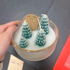 a person is holding a small christmas tree candle