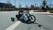 a man sitting on top of a motorcycle with wheels attached to the front and side