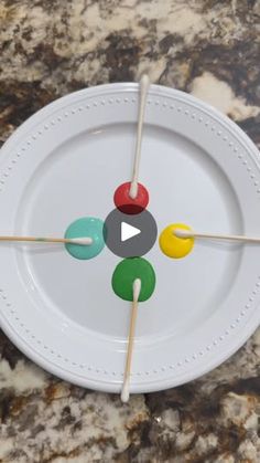 a white plate topped with four colorful toothpicks