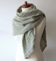 a white mannequin with a gray scarf on it