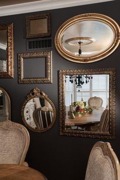 a dining room wall with mirrors and chairs