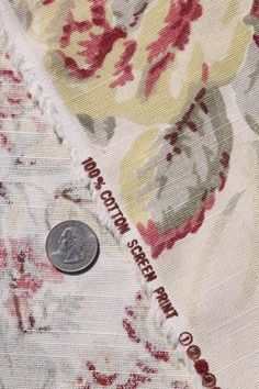 a coin sitting on top of a floral fabric