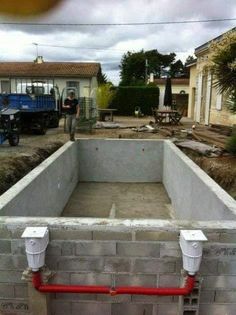 a man standing next to a cement pool under construction