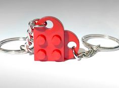 a red lego key chain with two heart shaped blocks attached to it's sides