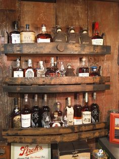 an old wooden shelf filled with liquor bottles