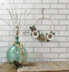 a vase with flowers and beads on a table in front of a white brick wall