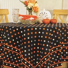 a polka dot table cloth with orange and blue dots on it, sitting on a wooden chair