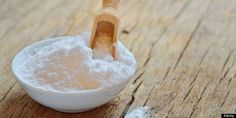 powdered sugar in a small white bowl with a wooden spoon on the table next to it