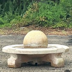 a stone bench sitting on top of a gravel field