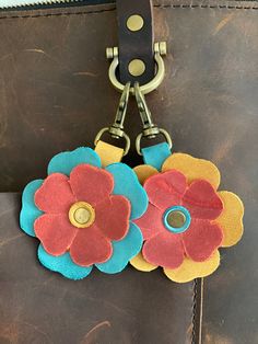 two flowers are attached to the handle of a purse