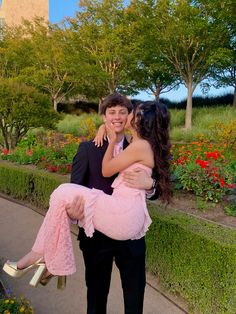 a man in a tuxedo is holding a woman on his back and she has her arms around him