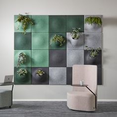 a chair and table in front of a wall mounted planter with succulents