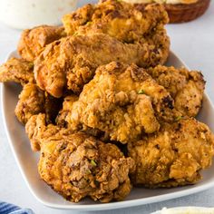 some fried food on a white plate with dipping sauce