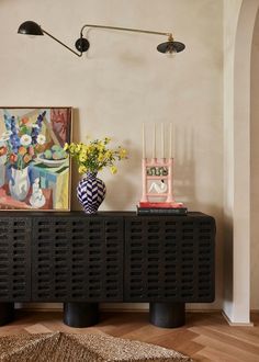 a living room with two vases and paintings on the wall