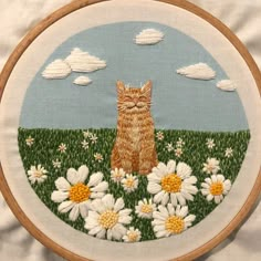 a cat is sitting in the middle of a field of daisies and daisies