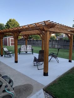 an outdoor patio with chairs and a pergolated area in the back yard,