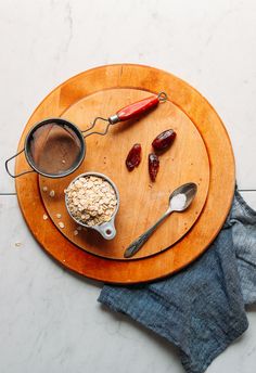 a wooden plate topped with ice cream next to two measuring spoons and a strainer