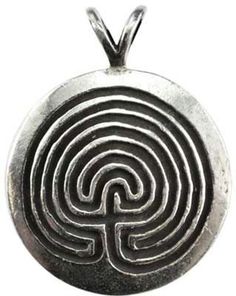 a silver pendant with a maze design on it