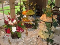 a table topped with lots of food and wine glasses on top of a white table cloth