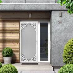 an entrance to a house with potted plants and trees in front of the door