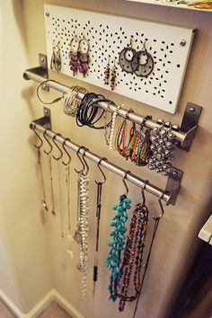 a wall mounted jewelry rack with several necklaces