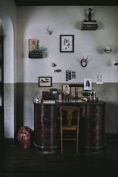 a desk with two chairs and pictures on the wall