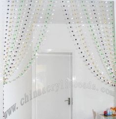 a room with a white door and some beads on the curtain over it's doorway