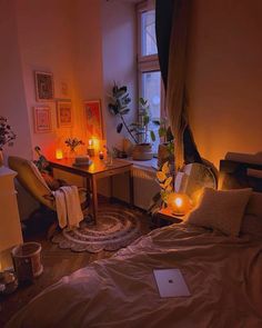 a room with a bed, desk and candles in it