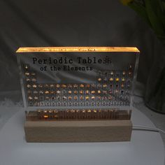 a table that has some kind of electronic device on it with the words periodic table of the elements lit up