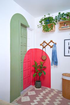 a potted plant sitting on top of a rug next to a red heart shaped door