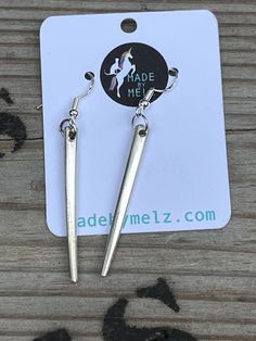 the earrings are made from metal and have long, pointed ends