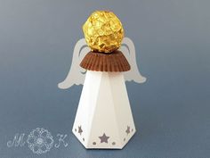 an origami angel with a golden ball on top