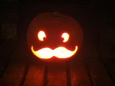 a carved pumpkin with an evil face on it's side, lit up in the dark