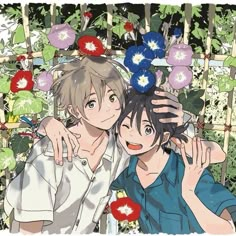 two people standing next to each other with flowers on their head in front of them