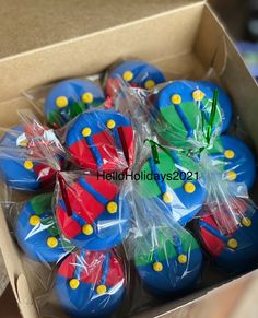 a box filled with blue and red cupcakes covered in plastic wrap around them