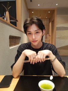 a man sitting at a table with chopsticks in front of him