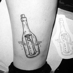 a black and white photo of a bottle tattoo on the left calf's leg