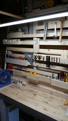 a workbench with tools hanging on the wall