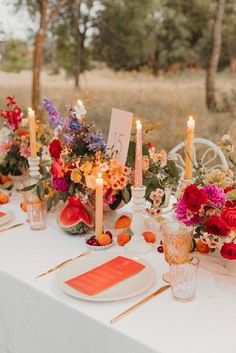 the table is set with flowers and candles