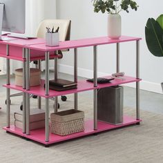 a computer desk with pink shelves in an office space next to a potted plant