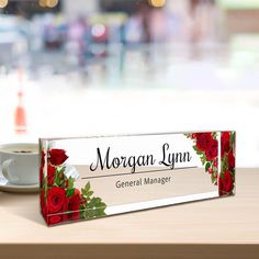 there is a sign that says morgan lynn general manager next to a cup of coffee