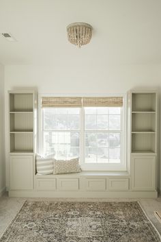 an empty room with built - in bookcases and a chandelier hanging from the ceiling