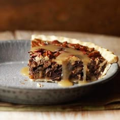 a slice of pecan pie on a plate with caramel sauce drizzled over it