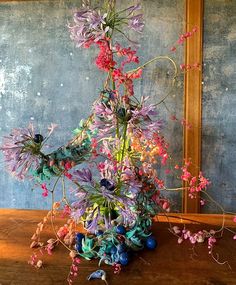 a vase filled with flowers sitting on top of a wooden table