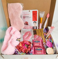 an open box filled with pink items on top of a white floor next to a stuffed animal